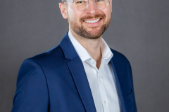 sydney-corporate-headshot-blue-suit-grey-background-matthew-with-a-camera