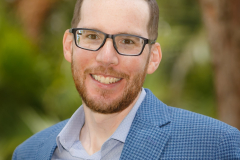 sydney-corporate-outdoor-headshot-blue-jacket-glasses-matthew-with-a-camera