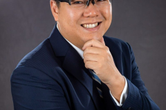 sydney-corporate-portrait-glasses-navy-jacket-hand-on-chin-matthew-with-a-camera